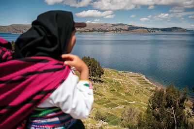 © Luis Herrera / Stocksy - Péruvienne devant le lac Titicaca, au Pérou Péruvienne devant le lac Titicaca, au Pérou