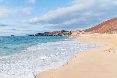 © lophius / Alamy / Hemis - Plage de Las Conchas avec l'île de Montana Clara en arrière-plan - La Graciosa - Îles Canaries - Espagne Plage de Las Conchas avec l'île de Montana Clara en arrière-plan - La Graciosa - Îles Canaries - Espagne