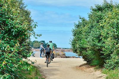 Randonneurs en vélo sur la Côte de Granit Rose en Bretagne - France