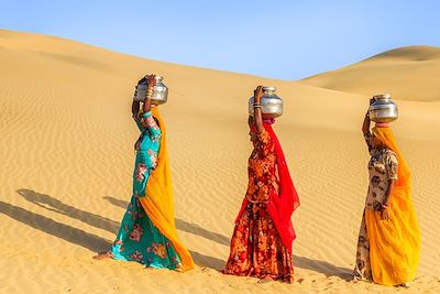 © Hadynyah / Getty Images - Des femmes indiennes portent des jarres d'eau dans le desert, Inde Des femmes indiennes portent des jarres d'eau dans le desert, Inde