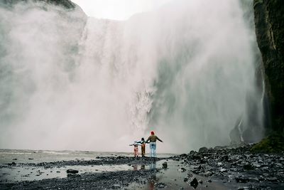 Une famille devant une cascade - Islande
