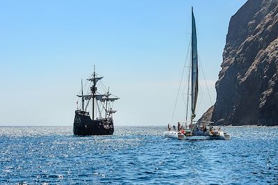 © a_mikhail / Adobe Stock - Réplique du navire historique de Christophe Colomb Santa Maria et catamaran de plaisance au large de Madère - Portugal Réplique du navire historique de Christophe Colomb Santa Maria et catamaran de plaisance au large de Madère - Portugal