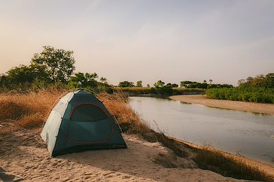 Tente de camping au bord d’une rivière en pleine nature au Sénégal
