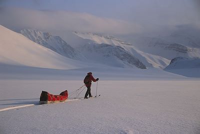 Personne skiant à travers la neige de Ny Alesund à Longyearbyen
